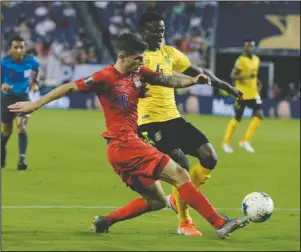  ?? The Associated Press ?? BATTLE FOR THE BALL: United States midfielder Christian Pulisic (10) kicks the ball past Jamaica midfielder Andre Lewis (4) during the second half of Wednesday’s CONCACAF Gold Cup semifinal soccer match in Nashville, Tenn. The United States won 3-1.