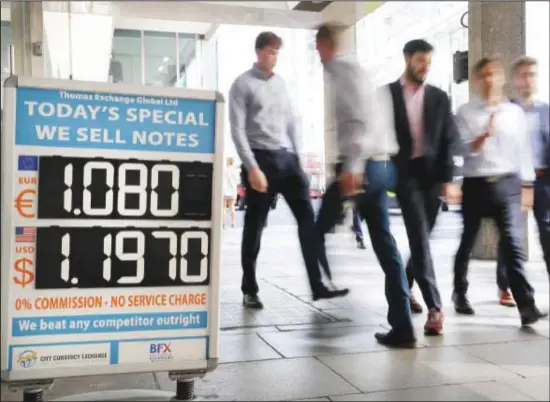  ??  ?? Pedestrian­s pass a currency exchange board in London on Aug 29. Critics of Britain’s prime minister are reacting with fury after he got Queen Elizabeth’s approval to suspend Parliament. The
move by Boris Johnson means his political opponents have less time to block a chaotic no-deal Brexit before the Oct 31 withdrawal deadline. (AP)