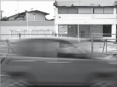  ??  ?? A car drives past in front of a closed gas station in Chiba, east of Tokyo, Japan June 28.