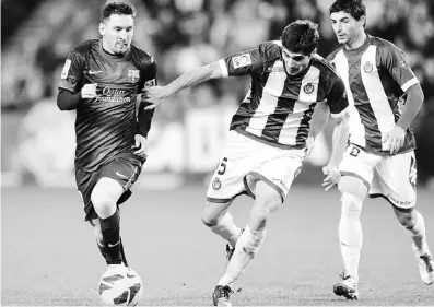  ??  ?? MESSI lucha por el balón con Henrique Sereno, del Valladolid, mientras Oscar González observa a la derecha.
