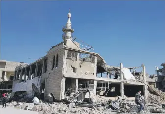  ?? AFP ?? A man rides his bike past a destroyed mosque in Arbin, Eastern Ghouta