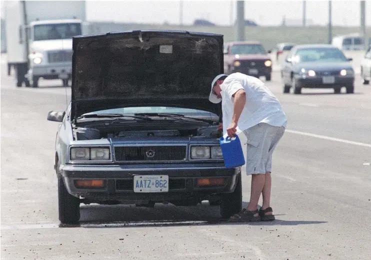  ?? — POSTMEDIA NETWORK FILES ?? Things couldn’t have got much worse for this driver, whose car broke down with an overheated radiator on a sweltering day on a busy highway.