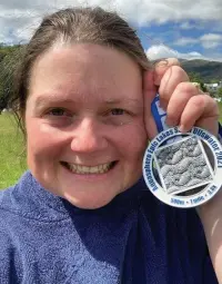  ??  ?? Head of Geography at Haslingden High School Charlotte Haworth with her medal for completing a mile swim in Ullswater.
