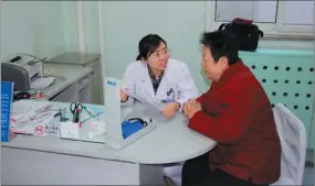  ?? PROVIDED TO CHINA DAILY ?? Gao Fengjuan, a general practition­er from the Desheng community health service center reviews a contract with a patient. The center’s goal is better long-term care for patients.