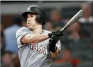  ?? JOHN BAZEMORE, FILE — THE ASSOCIATED PRESS ?? Miami Marlins’ J.T. Realmuto follows through on two-run base hit in the fourth inning of a baseball game against the Atlanta Braves in Atlanta.