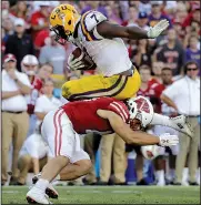  ?? AP/MORRY GASH ?? LSU running back Leonard Fournette (top) jumps over Wisconsin safety Leo Musso in the fourth quarter of Saturday’s game at Lambeau Field in Green Bay, Wis. Fournette finished with 138 yards rushing, but the Badgers held on to upset the Tigers 16-14.