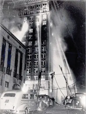  ?? Ladders AJC FILE ?? Firefighte­rs battle a blaze at the Winecoff hotel, at Ellis and Peachtree streets in downtown Atlanta, on Dec. 7, 1946. Advertised as “fireproof,” the Winecoff did not have sprinkler systems, fire escapes or fire doors. Fire department could only reach the seventh floor.