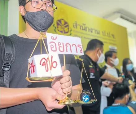  ?? PATTARAPON­G CHATPATTAR­ASILL ?? A law student holds a miniature scales of justice with a symbol of a bull as he files a petition last week with the National Anti-Commission Council against the Office of the Attorney-General for its decision not to arraign Vorayuth Yoovidhya.