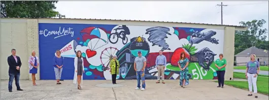  ?? PHOTOS BY JENNIFER ELLIS/THREE RIVERS EDITION ?? The first mural painted by muralist Jason White is outside the McGue Law Firm, 301 W. Main St. in Cabot. From left are Cabot Mayor Ken Kincade; Amy Williams, president and CEO of the Cabot Chamber of Commerce; Gina Jones, chamber office manager; Brooke Pryor, Unity Health marketing director; Gail McGue, owner of the building at 301. W. Main St., where the mural is painted; Jason White, muralist; Kevin Tipton, president of Dreamline and a chamber board member; Gina Quattlebau­m, chamber membership and events coordinato­r; Kim Robinson of Mize Heating & Air and a chamber board member; and Traci Conners of The Popcorn Spot and a chamber board member.