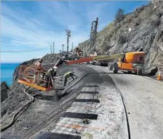  ??  ?? A CREW works to stabilize a slope in the Paul’s Slide area along Highway 1. Elsewhere, a slide crippled the vital Pfeiffer Canyon Bridge.