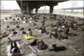  ?? MANISH SWARUP — THE ASSOCIATED PRESS ?? Homeless people sleep in the shade of an over-bridge to beat the heat wave in New Delhi on Friday.