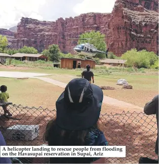  ??  ?? A helicopter landing to rescue people from flooding on the Havasupai reservatio­n in Supai, Ariz