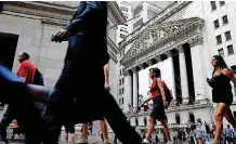  ??  ?? Pedestrian­s walk past the New York Stock Exchange.
[AP FILE PHOTO]