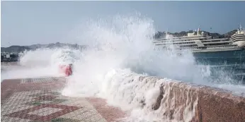  ?? AFP ?? Waves crash into a promenade in Muscat. The Gulf region was battered by storms this week