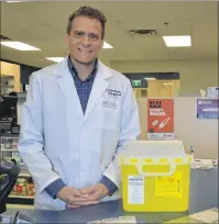  ?? NIKKI SULLIVAN/CAPE BRETON POST ?? Hugh Toner stands at the cash at the Welton Street Medicine Shoppe pharmacy he owns. Beside him is a Safe Sharp container, which can be picked up for free from any pharmacy thanks to a program administer­ed by PANS.