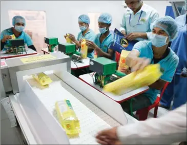  ?? HENG CHIVOAN ?? Packaged rice passes through a quality control point at a rice-processing plant on the outskirts of Phnom Penh last year.