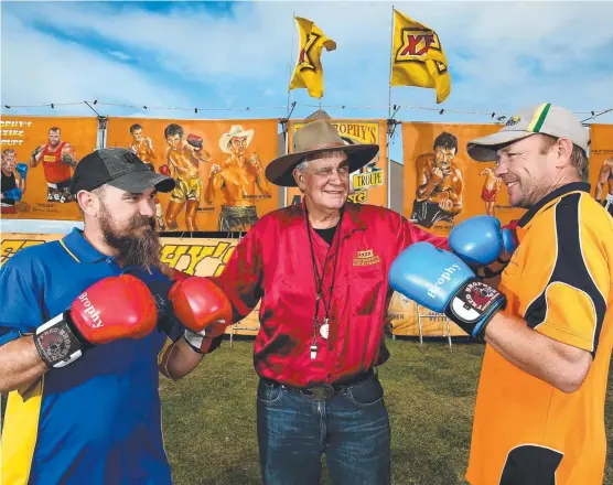  ?? Picture: DAVID CLARK ?? Showman Fred Brophy separates Kenny Watson and Steve Harle before today’s boxing tent showdown at the Gold Coast Turf Club.