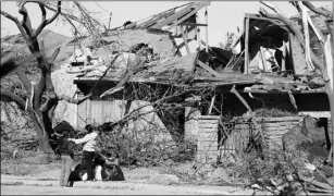  ?? AP PHOTO/LM OTERO ?? Women stand outside a house damaged by a tornado in the Preston Hollow section of Dallas, on Monday.