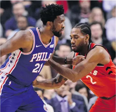  ?? FRANK GUNN / THE CANADIAN PRESS ?? Kawhi Leonard has guided the Raptors to the best record in the NBA with a 21-5 mark. Leonard was stellar in a 36-point, nine-rebound, five-steal night Wednesday against Joel Embiid, left, and the rival Philadelph­ia 76ers.