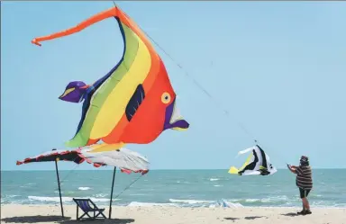  ?? LI MANG / XINHUA ?? A man wrestles with his kite during the Thailand Internatio­nal Kite Festival at Cha-Am Beach in central Thailand on Friday. The festival has been running for the past 10 years.