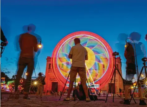  ?? Foto: Peter Kneffel, dpa ?? Auf dem Münchner Königsplat­z steht derzeit ein Riesenrad, das ein beliebtes Fotomotiv ist. In Augsburg werden ähnliche Pläne skeptisch gesehen.