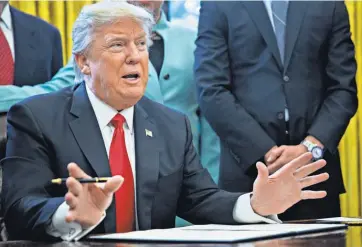  ?? POOL PHOTO BY ANDREW HARRER ?? President Trump, joinedMond­ay by leaders in small business, prepares to sign an executive order on federal regulation­s.