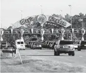  ?? OCTAVIO JONES/GETTY ?? Visitors’ vehicles crowd the entrance to Walt Disney World in Orlando. Fla. Gov. Ron DeSantis has signed a law dissolving the attraction’s private government.