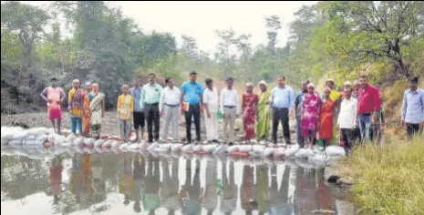  ??  ?? Officials place cement bags to build small dams at a village in Murbad so that farmers have enough water rabi crops.
HT PHOTO