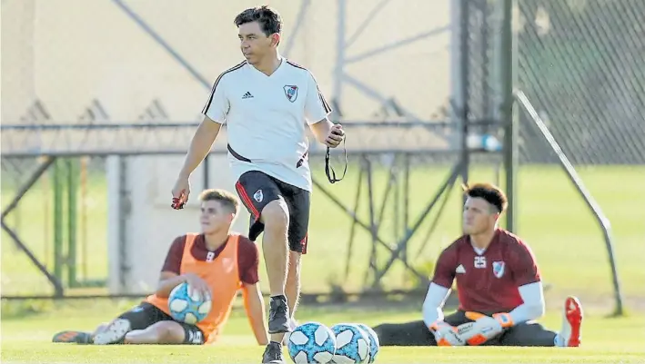  ??  ?? La pelota bajo la suela. Marcelo Gallardo, con el cronómetro y el silbato en sus manos, dirige la práctica de River ante la atenta mirada de Julián Álvarez y Enrique Bologna.