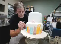  ?? (Rick Wilking/Reuters) ?? BAKER JACK PHILLIPS decorates a cake at his Masterpiec­e Cakeshop in Lakewood, Colorado, in September.