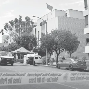  ?? — Gambar AFP ?? MENGEJUTKA­N: Kakitangan pejabat koroner mengalihka­n mayat suspek dari pekarangan konsulat China (kanan) di Los Angeles, California kelmarin.