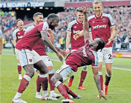  ?? ?? Killer blow: Michail Antonio is swamped by his West Ham team-mates after beating Harry Kane to the ball and scoring the winner