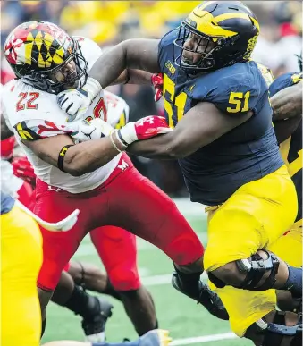  ?? TONY DING/THE ASSOCIATED PRESS ?? The mother of Michigan centre Cesar Ruiz, right, figured her son would never be home in New Jersey after leaving home to play football. But he’ll back this week to play at Rutgers.