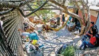  ??  ?? Una familia de residentes de Las Torres hicieron la división fronteriza parte de su casa: construyer­on sus cuartos y hasta un pequeño local de abarrotes, con un patio en medio de todos ellos, en el que crecieron árboles.