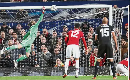  ?? — Reuters/AFP ?? In it goes: Manchester United goalkeeper David De Gea trying to save a shot from Sevilla’s Wissam Ben Yedder during the Champions League last-16 second-leg match at Old Trafford on Tuesday. Inset: United’s Chris Smalling (right) vying for the ball with...