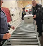  ?? PHOTO COURTESY OF LANSDALE POLICE DEPARTMENT ?? Lansdale police Officer David Pelzer, right, helps pass on food donated during the annual Lt. Patty Simons food drive for the Norristown Salvation Army shelter in December 2021.