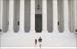  ?? Drew Angerer / Getty Images ?? People walk up the steps of the U.S. Supreme Court on Monday in Washington, D.C. The Supreme Court issued a unanimous opinion on Monday that said states can require Electoral College voters to back the winner of their states popular vote in a presidenti­al election.