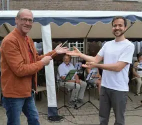  ?? FOTO ?? Koen Thijs geeft het dirigeerst­okje van koninklijk­e harmonie Sint-Amelberga door aan Jun den Oudsten.