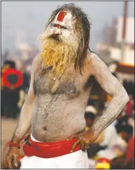  ??  ?? A Hindu holy man watches pilgrims walk past during the festival.