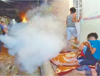  ??  ?? Dos hombres con chalecos verdes y el logo de Chiapas nos Une pasaron con una bomba aspersora y lanzaron clorpirifo­s en calles de Huixtla. La sustancia química se usa para el combate del zancudo.