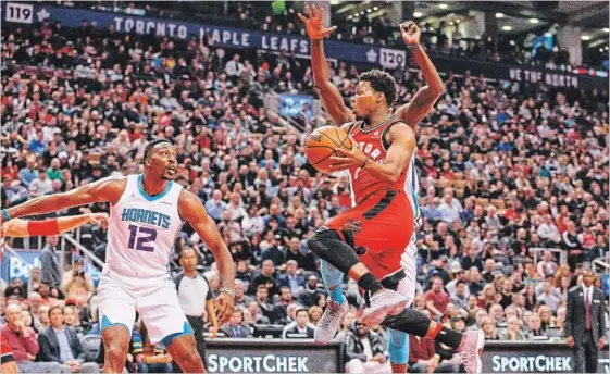  ?? CARLOS OSORIO TORONTO STAR ?? Dwight Howard, left, of the Charlotte Hornets watches as Toronto Raptors’ Kyle Lowry drives to the basket in the first half Sunday at the Air Canada Centre.