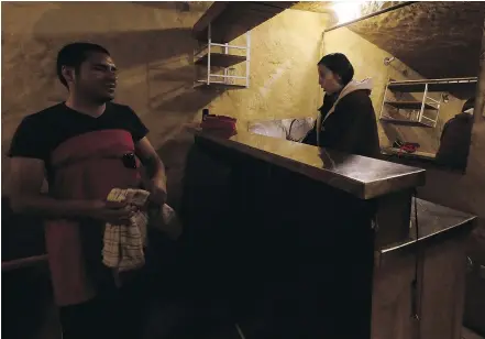  ?? — THE ASSOCIATED PRESS ?? Visually impaired waiter Jessica Aguilar, right and blind waiter Gabriel Bolanos, prepare for the arrival of guests at La Cueva de Rafa, or Rafa’s Cave restaurant, in Quito, Ecuador.