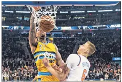  ?? Corey Sipkin ?? SLAMMED SHUT: Kristaps Porzingis watches Wilson Chandler slam home two of his 19 points during the first half.