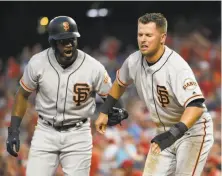  ?? Nick Wass / Associated Press ?? Denard Span (left) helps Joe Panik get up after Panik was hit in the head by a throw and tagged out at home plate.