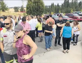  ?? Dan Pelle Spokesman-Review ?? PARENTS gather at Freeman High School in Rockford, Wash., after the shooting. One student said the suspect had been obsessed with school shootings.