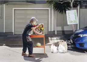  ??  ?? Colleen Irwin, a nurse practition­er at San Francisco General Hospital, set up a food pantry outside her home in the Bernal Heights.