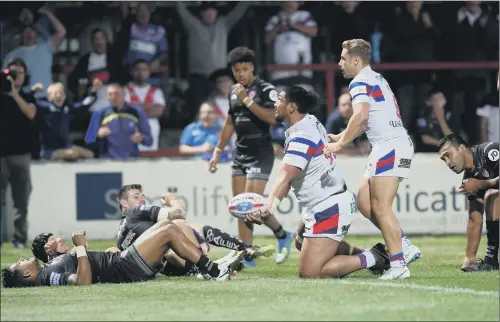  ??  ?? Burly Wakefield forward Pauli Pauli wipes out the St Helens cover to score Trinity’s second try in last night’s 36-16 home defeat against St Helens.