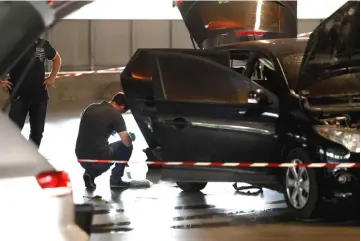  ??  ?? A forensic police officer investigat­ing a car abandoned by Faid at O’Parinor shopping mall parking area after his escape onboard a helicopter from a prison in Reau. —AFP photos