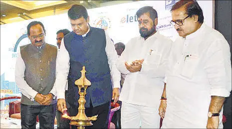  ?? RISHIKESH CHOUDHARY ?? Chief minister Devendra Fadnavis inaugurate­s the Smart City summit at Kalyan Sports Complex on Friday. (Right) The CM, flanked by KDMC commission­er E Ravendiran and mayor Rajendra Devlekar, shows the Smart City app.