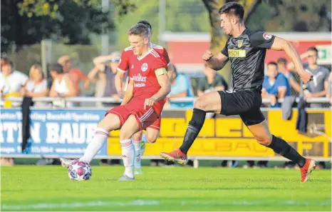  ?? FOTO: THOMAS WARNACK ?? Pascal Schoppenha­uer (links) ist mit zwölf Toren der erfolgreic­hste Schütze des TSV Riedlingen in dieser Saison. Gegen den FC Mengen (rechts: Dennis Ivanesic) trug er in Vertretung von Fabian Ragg auch die Kapitänsbi­nde.